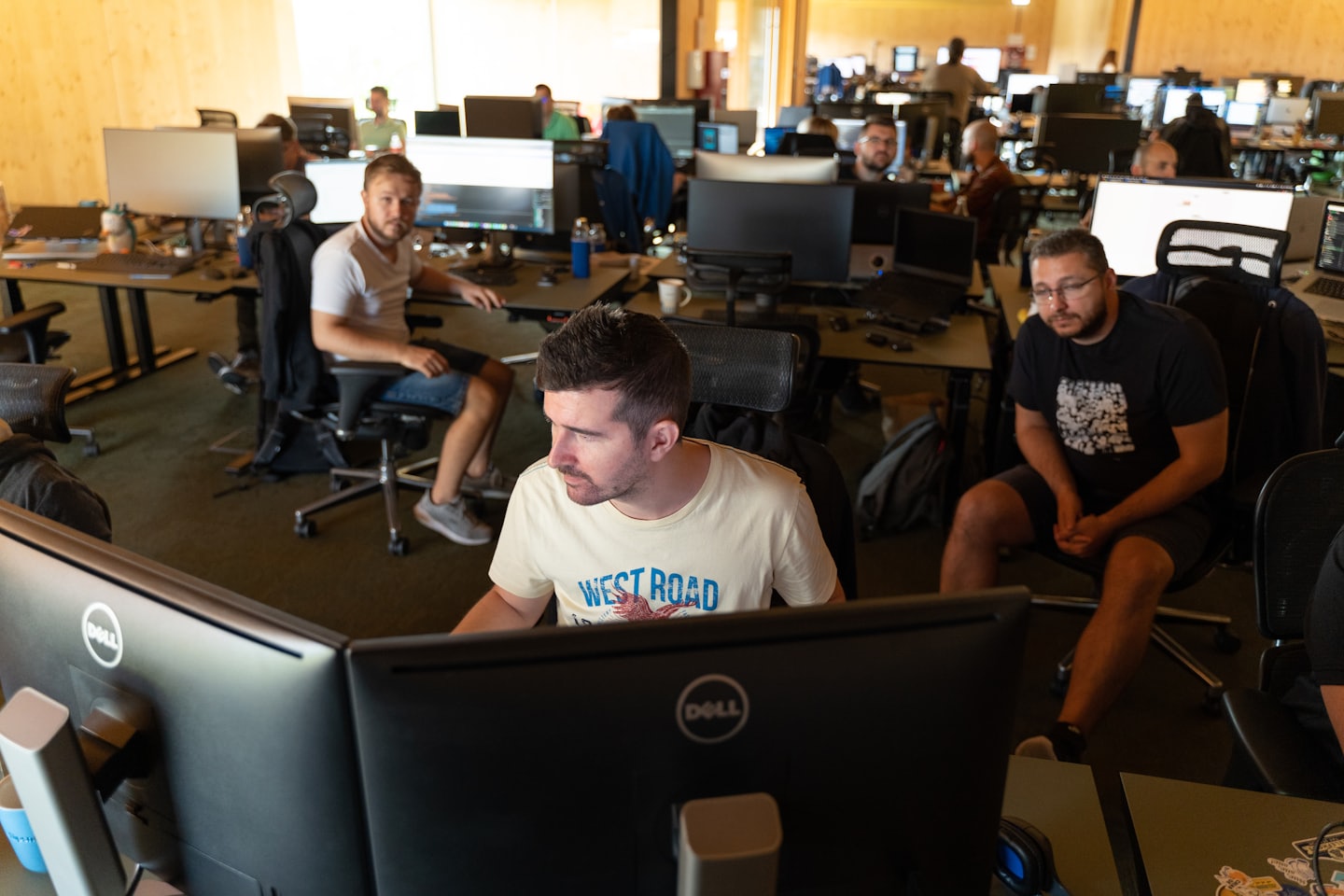 Professionisti IT che collaborano alle loro scrivanie in un ufficio moderno.
